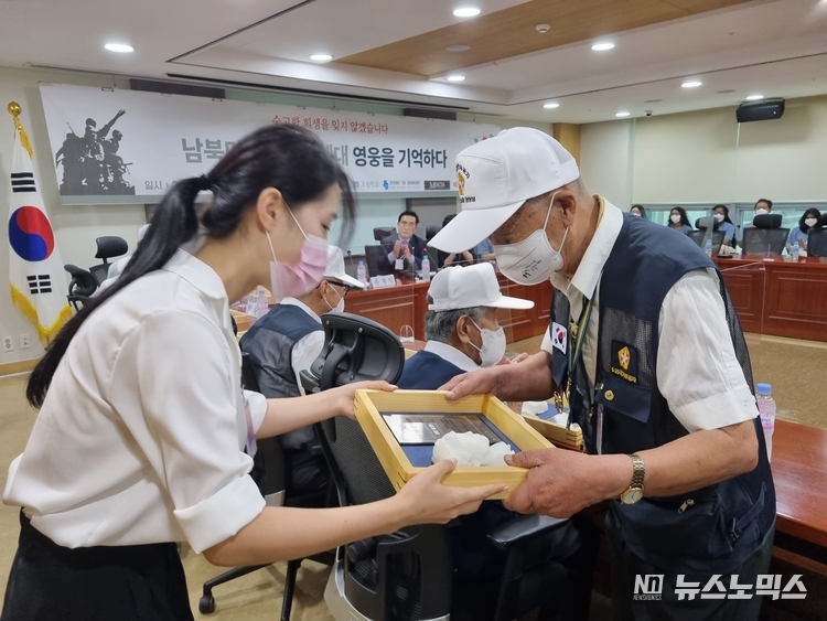 지난 18일 태영호 국회의원실 주관으로 국회에서 열린 ‘남·북·미 MZ세대 영웅을 기억하다’간담회에 참석한 참전영웅에게 이들이 '6.25 전쟁 전사자 유해 발굴 캠프'에 참가한 남북, 미국 등의 청년들이 제작한 ‘6·25참전 영웅’ 흉상 감사패를 전달하고 있다./(사)비욘드더바운더리 제공