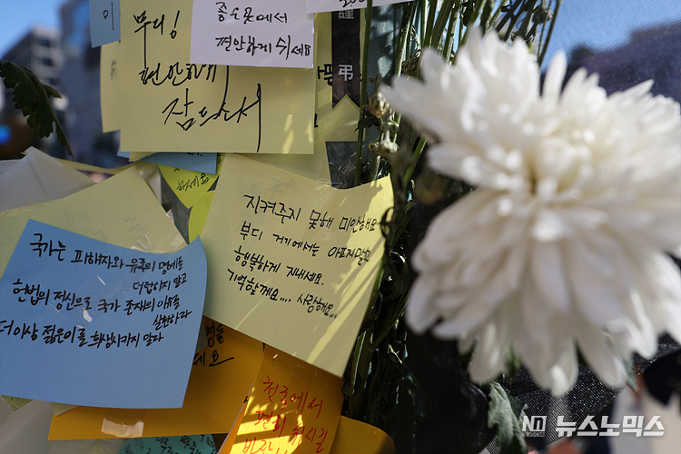 5일 서울 용산구 이태원역 1번출구에 마련된 이태원 참사 추모공간에서 시민들이 희생자들을 위해 꽃을 두며 추모하고 있다. ⓒ정의철 기자
