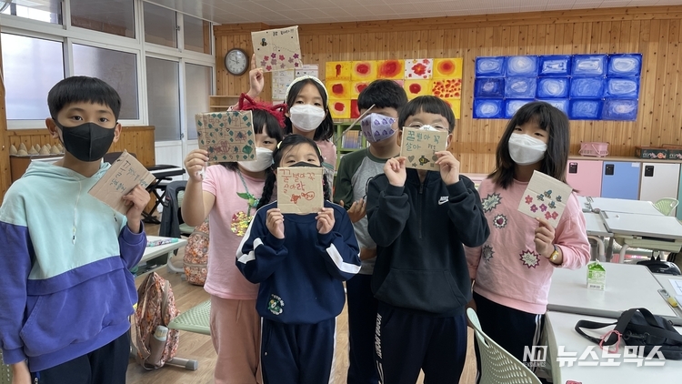 진주대곡초등학교 3학년 학생들과 '꿀벌의 노래'팀이 11월초부터 2주간 동안 교실에서 꿀벌의 소중함에 대한 생태교육을 진행한 뒤 폐박스 종이에 '멸종 위기에 내몰린 공룡과 꿀벌'의 이야기를 담은 후 환하게 웃고 있다./사진='꿀벌의노래'팀