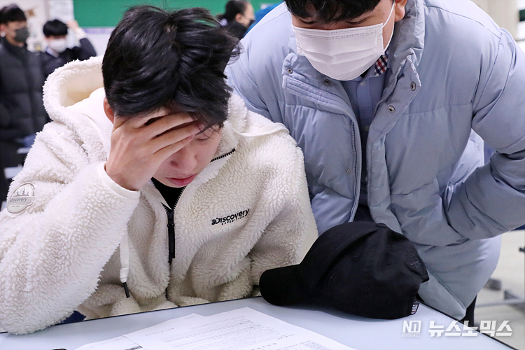 9일 서울 종로구 경복고등학교에서 학생들이 2023학년도 대학수학능력시험 성적통지표를 받아 점수를 확인하고 있다. ⓒ정의철 기자/POOL