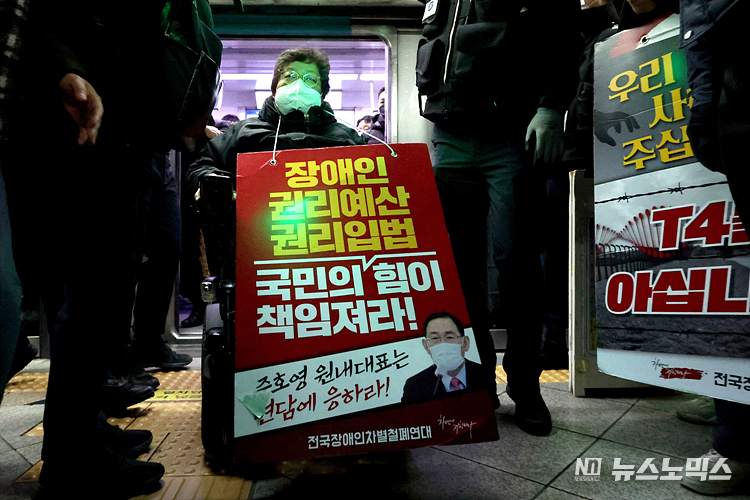 전국장애인차별철폐연대(전장연) 회원들이 12일 서울 용산구 삼각지역 4호선 승강장 앞에서 서울시의 무정차 통과 방안 검토를 규탄하며 장애인 권리 예산 확보를 위한 지하철 타기 선전전을 마친 후 지하철로 이동하고 있다. ⓒ정의철 기자