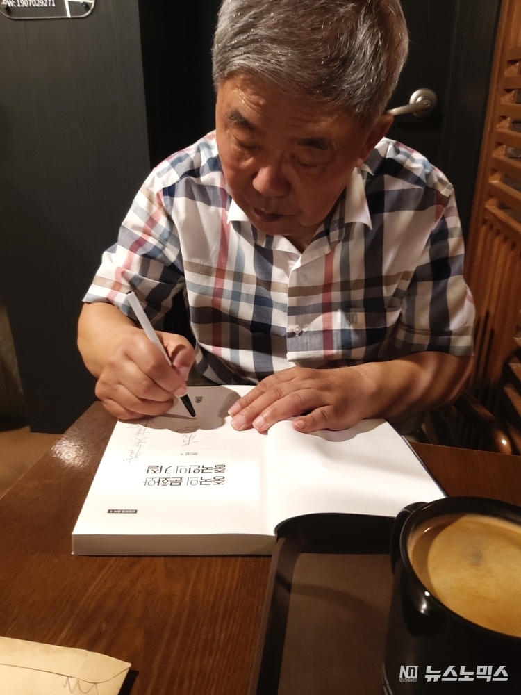 정인갑(75) 전 칭화대 교수가 최근 서울 대림동의 한 커피숍에서 본지 기자를 만나 책 내용을 설명하며 서명하는 모습