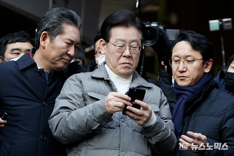 이재명 더불어민주당 대표가 설 명절을 앞두고 18일 서울 마포구 망원시장을 방문해 시장 상인들을 만난 뒤 검찰 소환에 대한 입장을 밝히기 전 핸드폰을 바라보고 있다. ⓒ정의철 기자(공동취재)