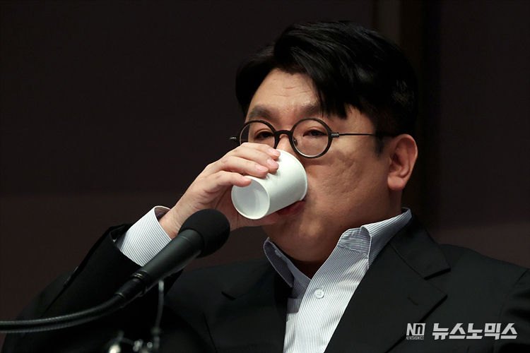 방시혁 하이브(HYBE) 이사회 의장이 15일 서울 중구 한국프레스센터에서 열린 관훈포럼 초청 강의에서 패널의 질문에 답하며 목을 축이고 있다. ⓒ정의철 기자
