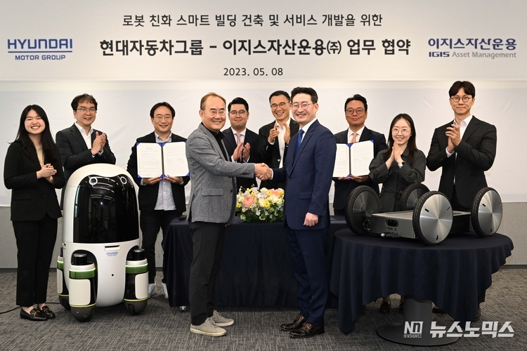 지난 8일 의왕연구소에 현대차∙기아의 실내외 배송 로봇(왼쪽)과 모베드(MobED, 오른쪽)가 놓인 가운데 현대차·기아 연구개발본부장 김용화 부사장(앞줄 왼쪽)과 이지스자산운용 리얼에셋부문 정석우 대표(앞줄 오른쪽)가 기념 사진을 촬영하고 있다./사진=현대자동차그룹