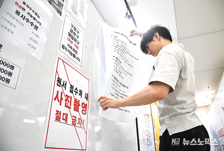 2024학년도 수능 원서 접수 첫날인 24일 서울남부교육지원청 관계자가 안내문을 부착하고 있다. ⓒ사진공동취재단