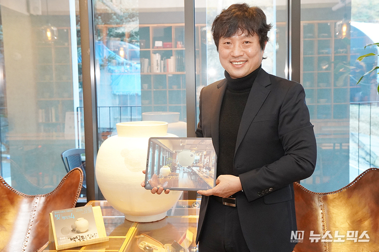 서영호 아이씨에프 대표가 변승훈 작가의 작품을 자사 AR 애플리케이션 ‘에이알쿠키’로 보여주고 있다