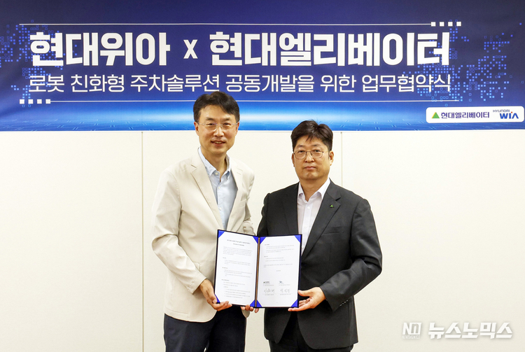 백익진 현대위아 모빌리티솔루션사업부장과 이원해 현대엘리베이터 승강기사업본부장이 현대위아 의왕연구소에서 업무협약(MOU)을 체결한 뒤 기념 촬영을 하고 있다