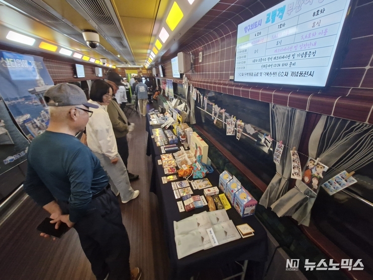 코레일 E-train 관광열차 내부 부산관광상품을 둘러보는 여행객 모습