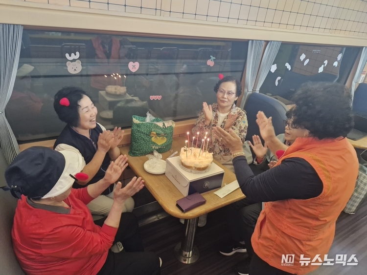 E-train 관광열차 내 70세 생신 축하 잔치 중인 동료 여행객들 모습